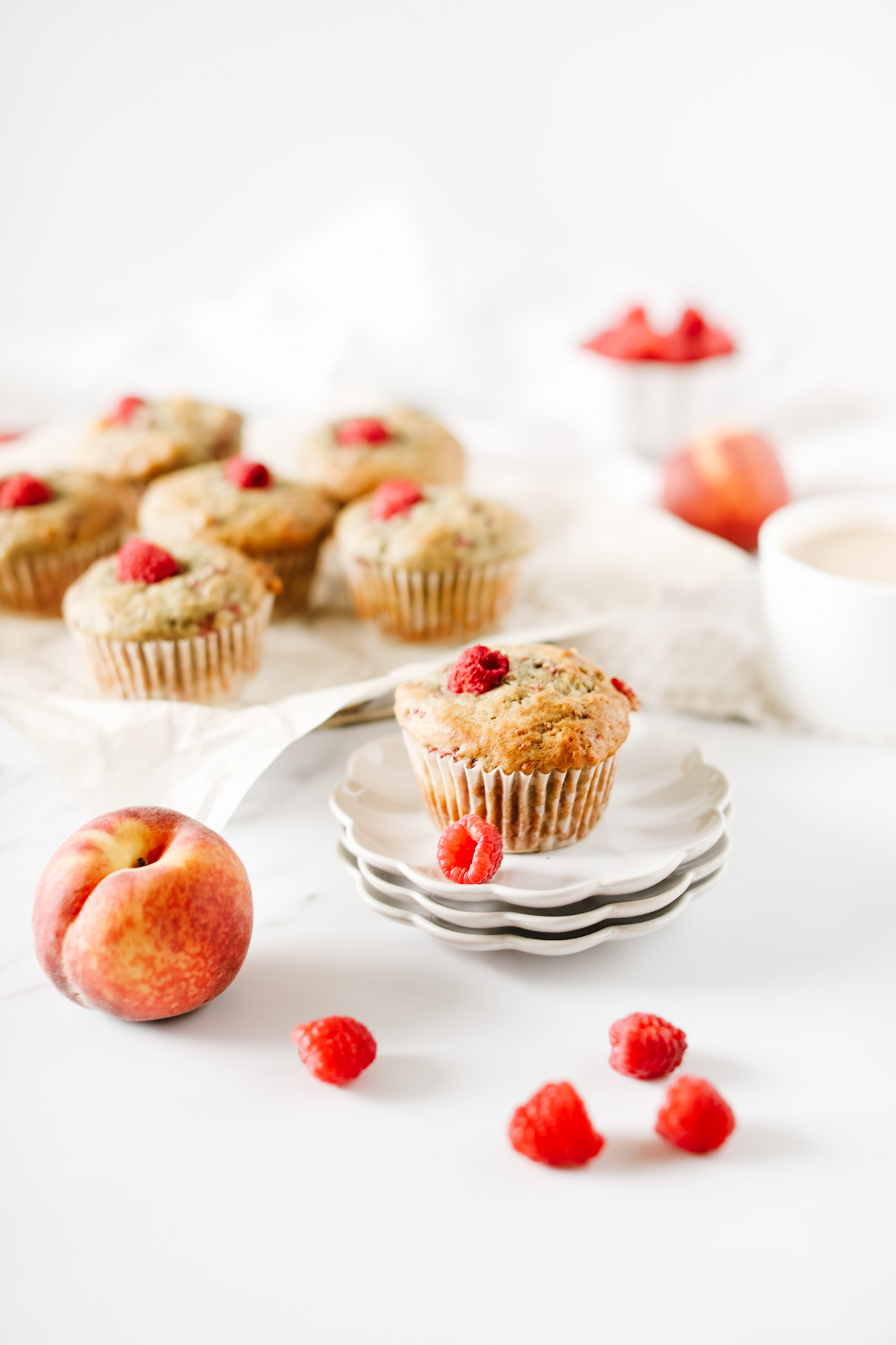 peach raspberry muffins by Fraiche Living on plate with fresh raspberries