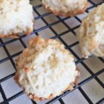 coconut macaroons fresh out of the oven on a black cooling rack