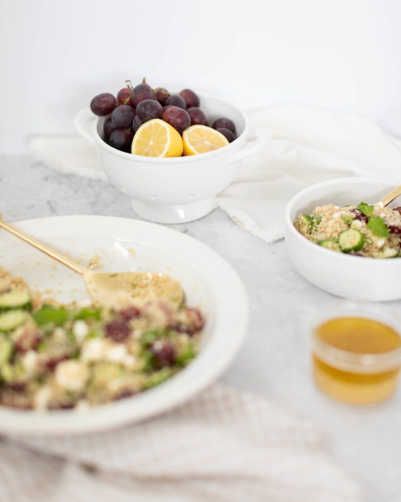 minted quinoa salad in a bowl with fresh grapes and lemon