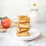 Gouda Apple & Thyme Grilled Cheese stacked up on a plate with an apple