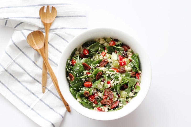 Kitchen Sink Salad in white bowl with wooden tongs