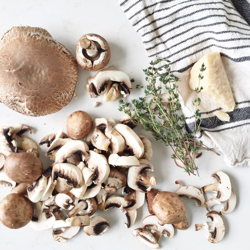 Sliced mushrooms on white counter with striped tea towel 