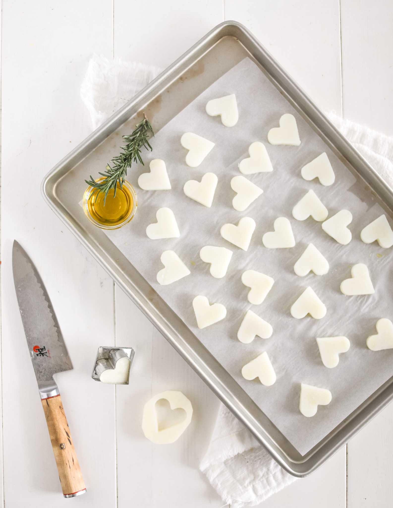 cutting potatoes into heart shapes with rosemary and olive oil