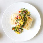 halibut plated with mango salsa and coconut rice on a white surface