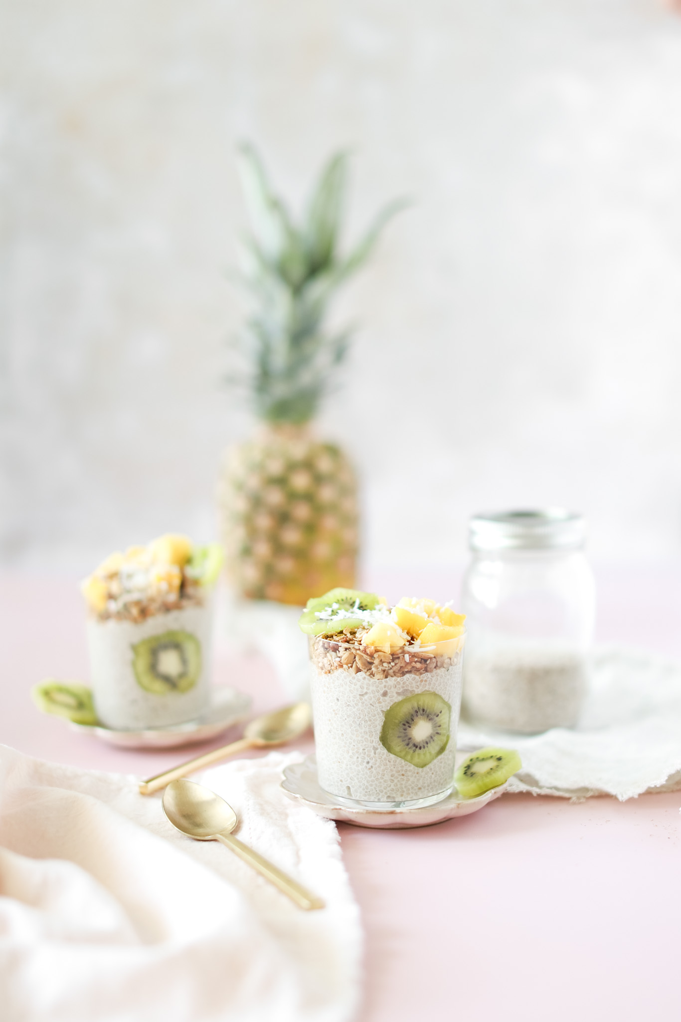 Tropical Chia Pudding in two glasses with kiwi and pineapple