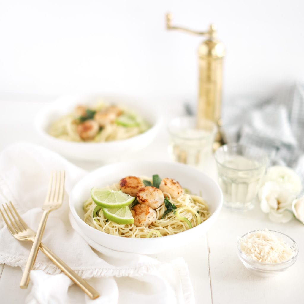 lime capellini pasts with scallops in two bowls