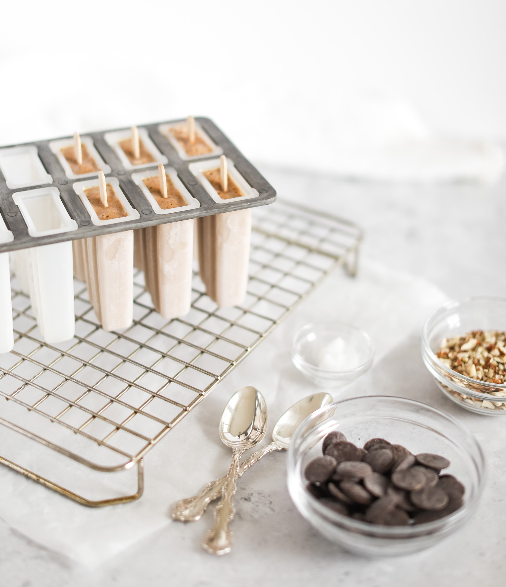 ingredients needed to make Almond Roca Popsicles like popsicle mould, chocolate, crushed almonds.