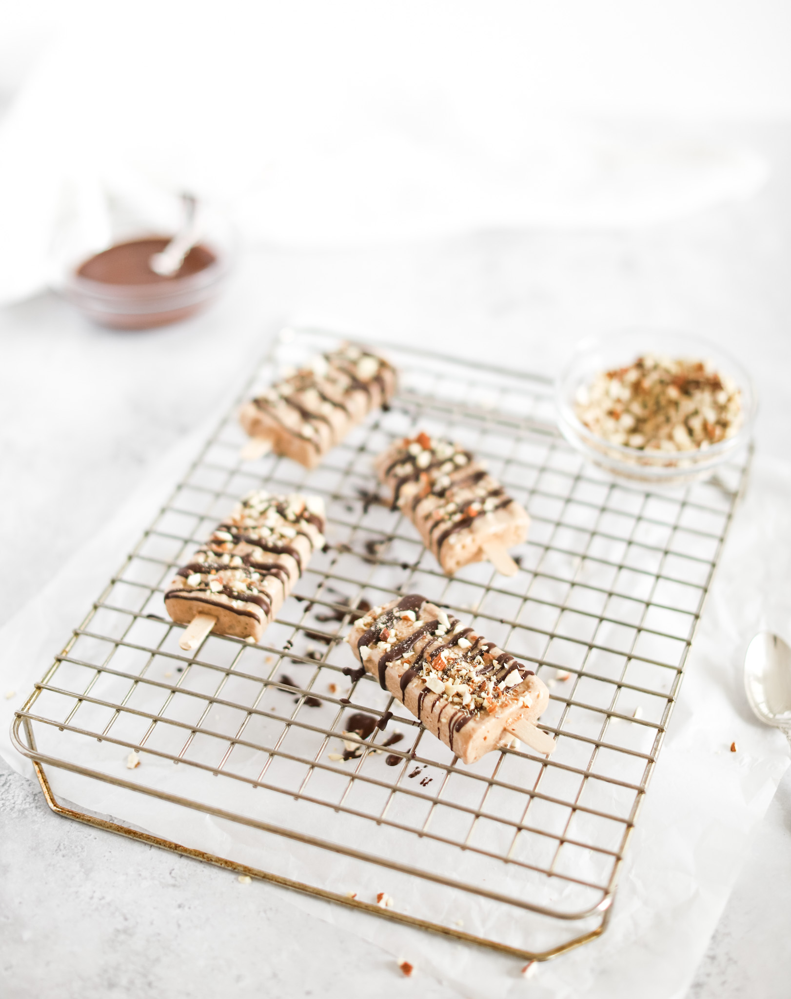Almond Roca Popsicles by Fraiche Living on drying rack covered with chocolate and nuts