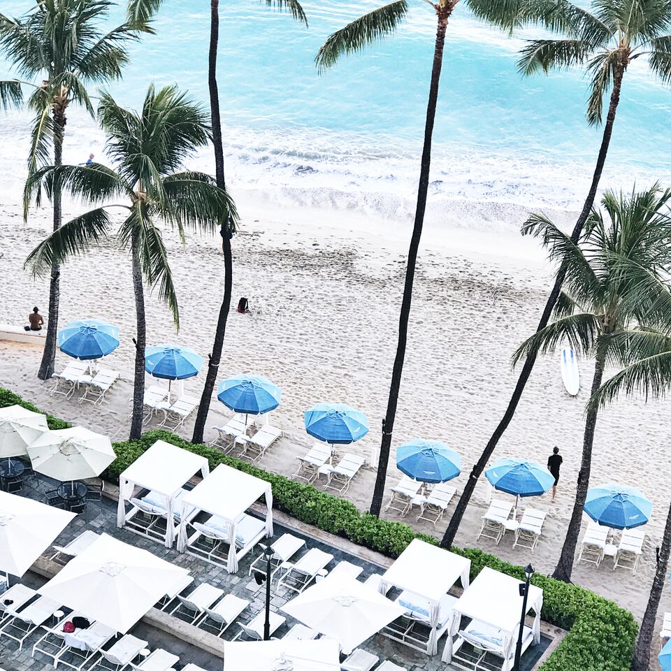Beach view with umbrella loungers at the Moana Surfrider Hotel in O'ahu
