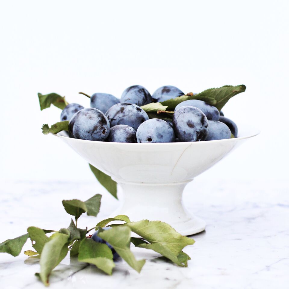 Fresh plums in white bowl 