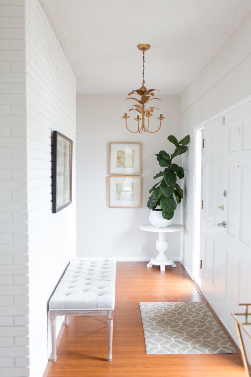 Benjamin Moore Intense White Walls with white painted brick fireplace and a gold palm Pottery Barn pendant light.