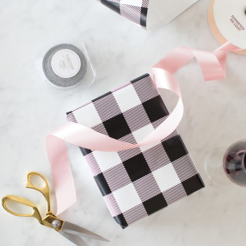 Black and White Buffalo Plaid wrapping paper with gold scissors and pink satin ribbon