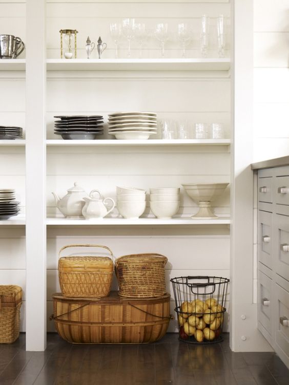 white open shelving in pantry with white bowls, teapots, glasses and baskets 