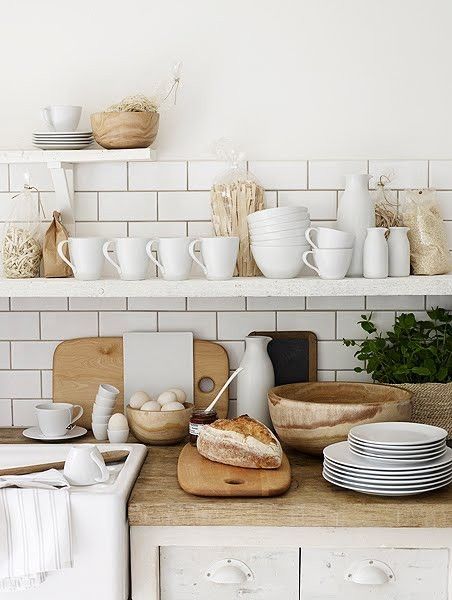 open shelves with white ware, wooden bowls, fresh bread and eggs