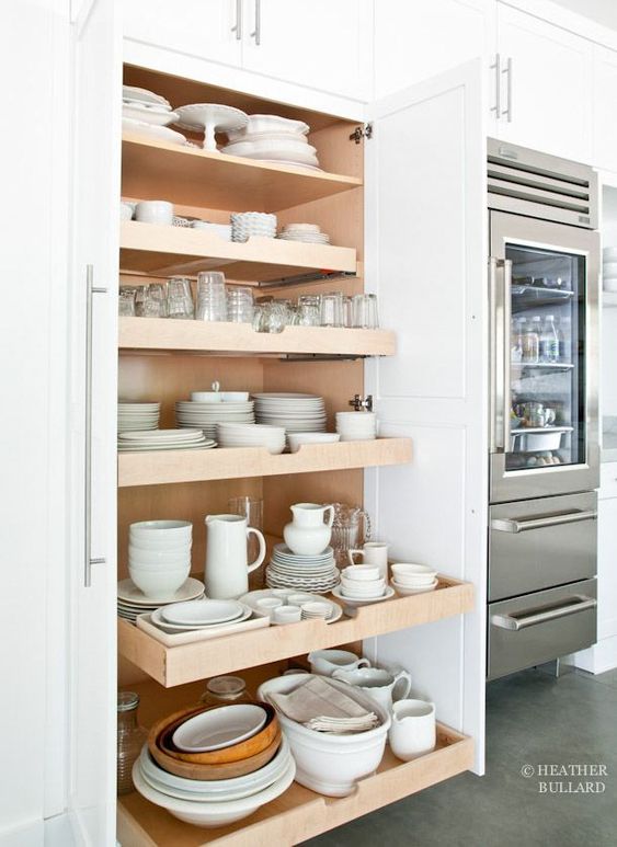 White industrial kitchen with natural wood roll out shelves for white kitchen ware