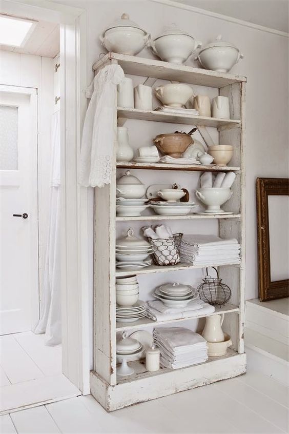 white vintage shelving for the pantry filled with vintage soup terrines, bowls, linens and more