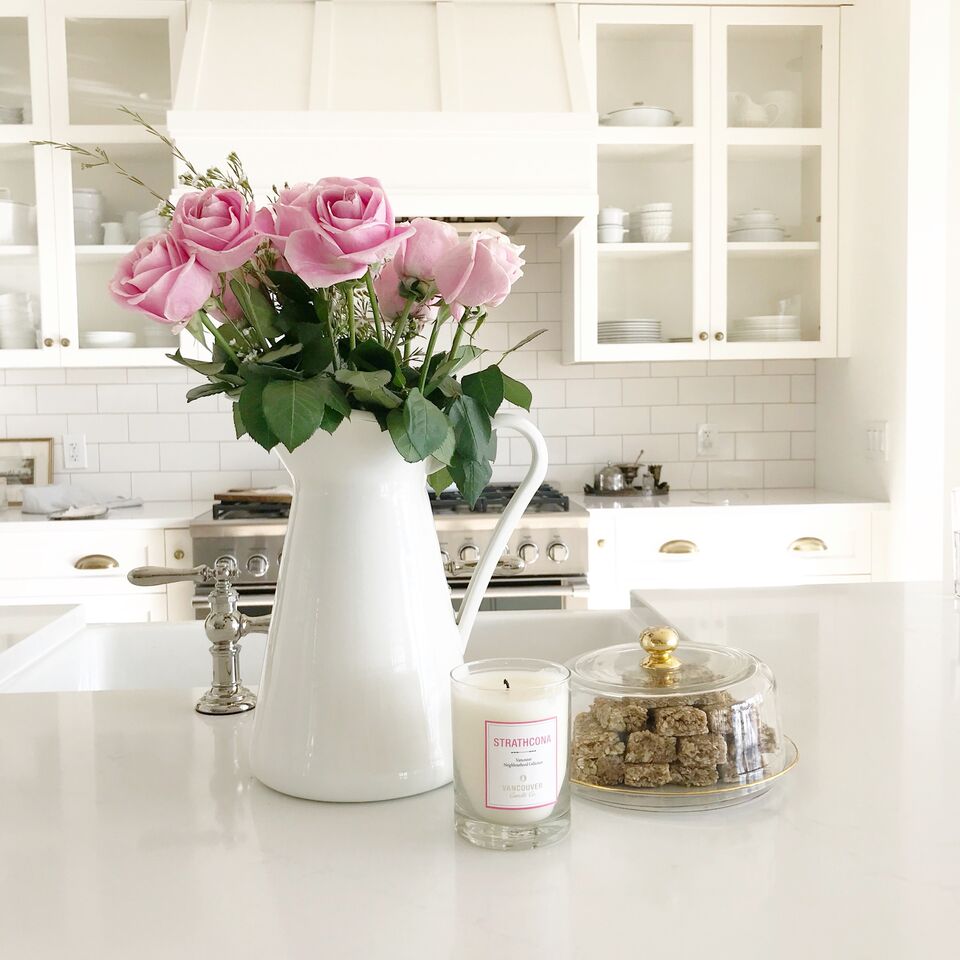 White kitchen with pink roses in a cream vase with a antique dome gold plate filled with homemade Orange Omega No Bake Granola Bars