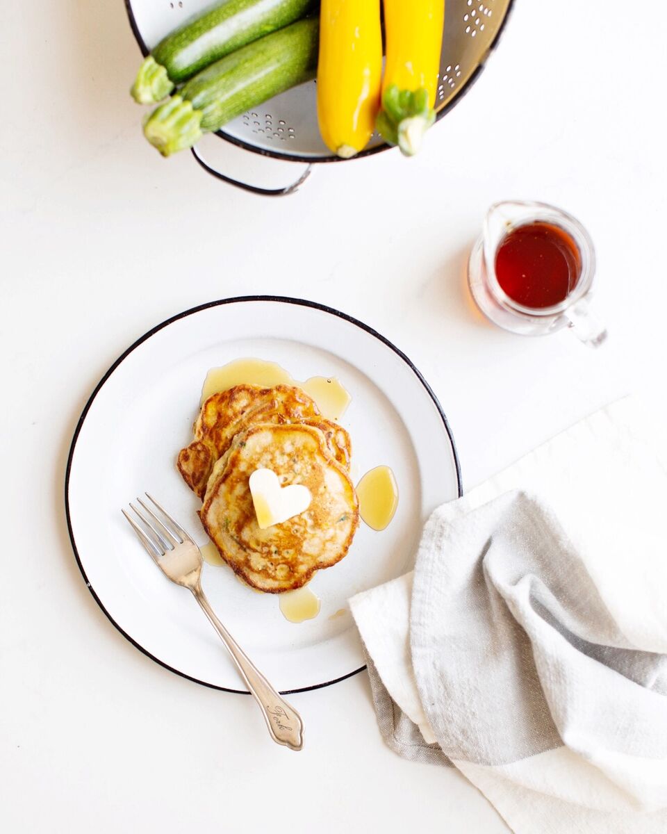 Zucchini Bread Pancakes with a heart shaped butter and maple syrup.