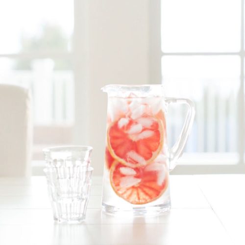 Pitcher of water with grapefruit. Dietitian's advice on 5 ways to improve your skin health with food.
