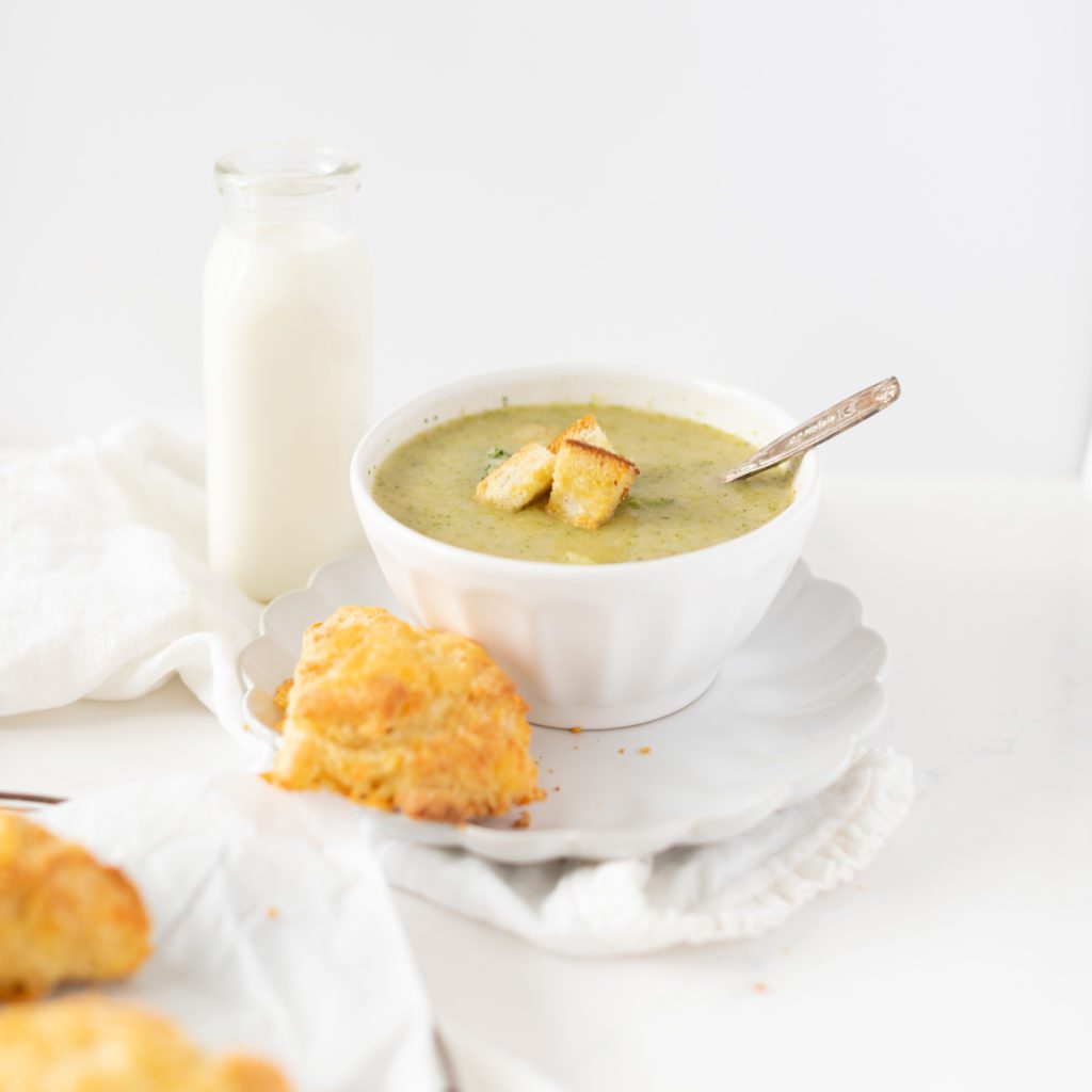 potato broccoli soup in a bowl with a cheddar scone