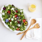 Spring Salad with edible flowers and creamy lemon vinaigrette.