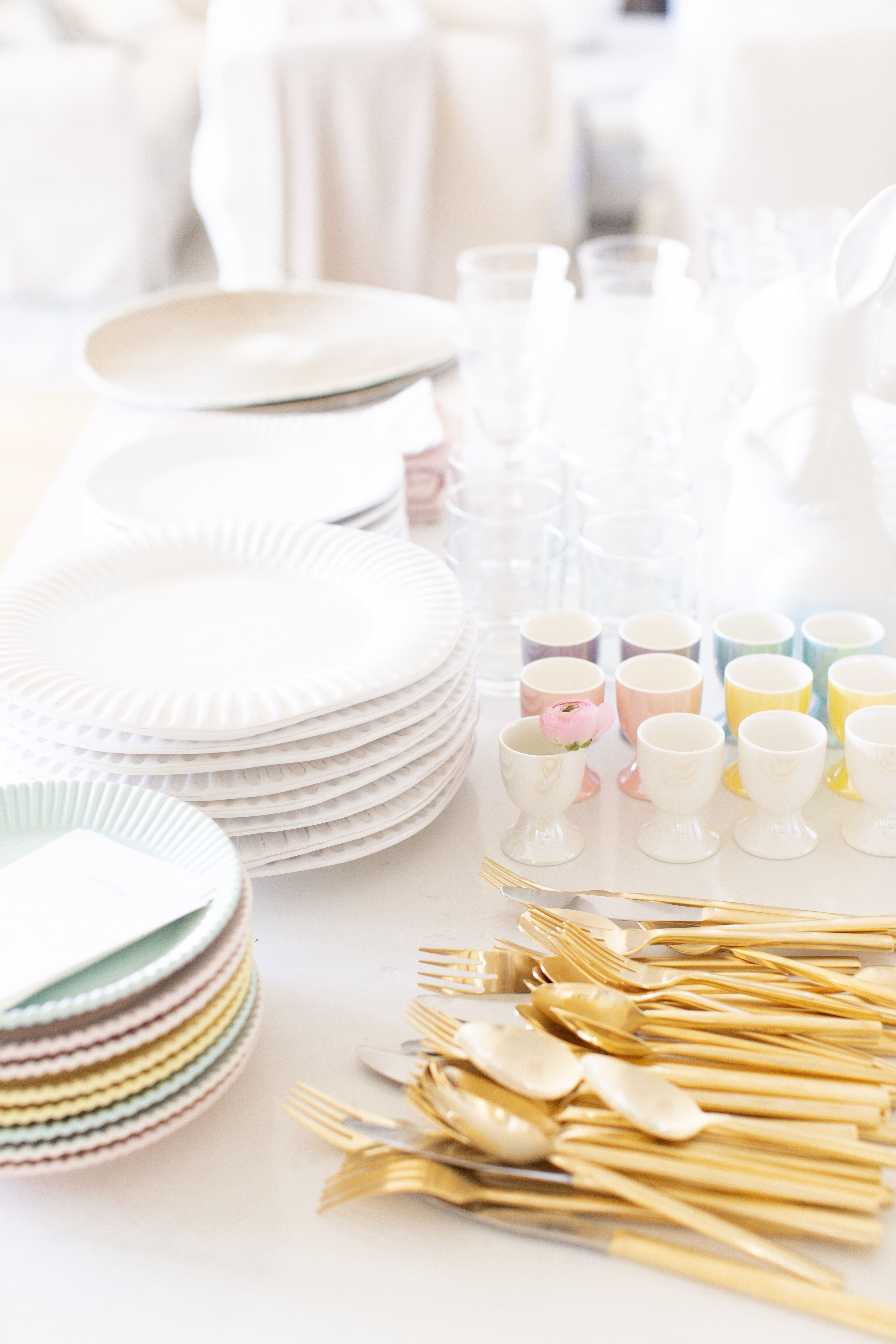 Easter dinner preparation with pastel egg cups and gold flatware