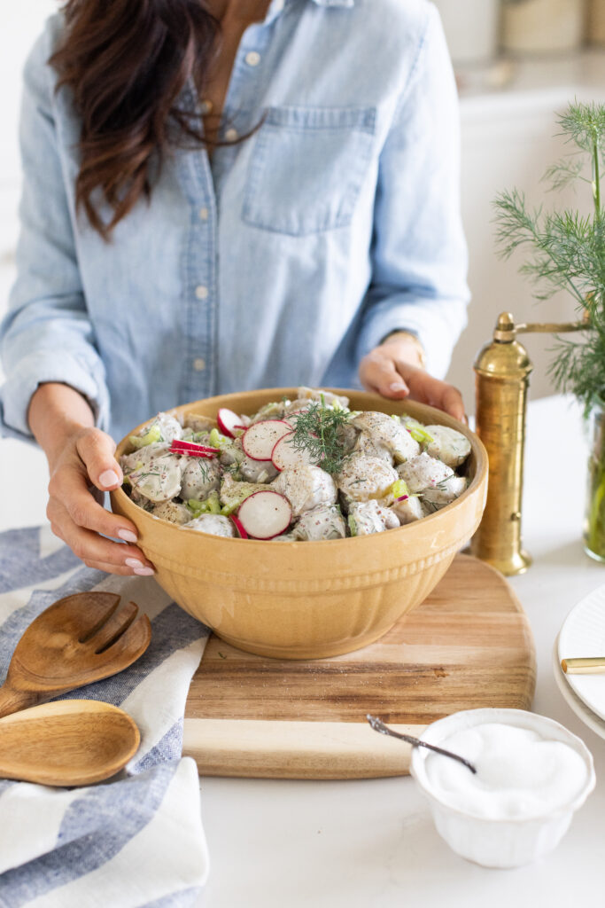 Tori with a bowl of creamy dill potato salad made with baby potatoes, radish and fresh dill