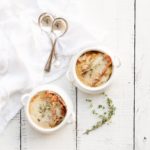 french onion soup on white wooden table by fraiche living