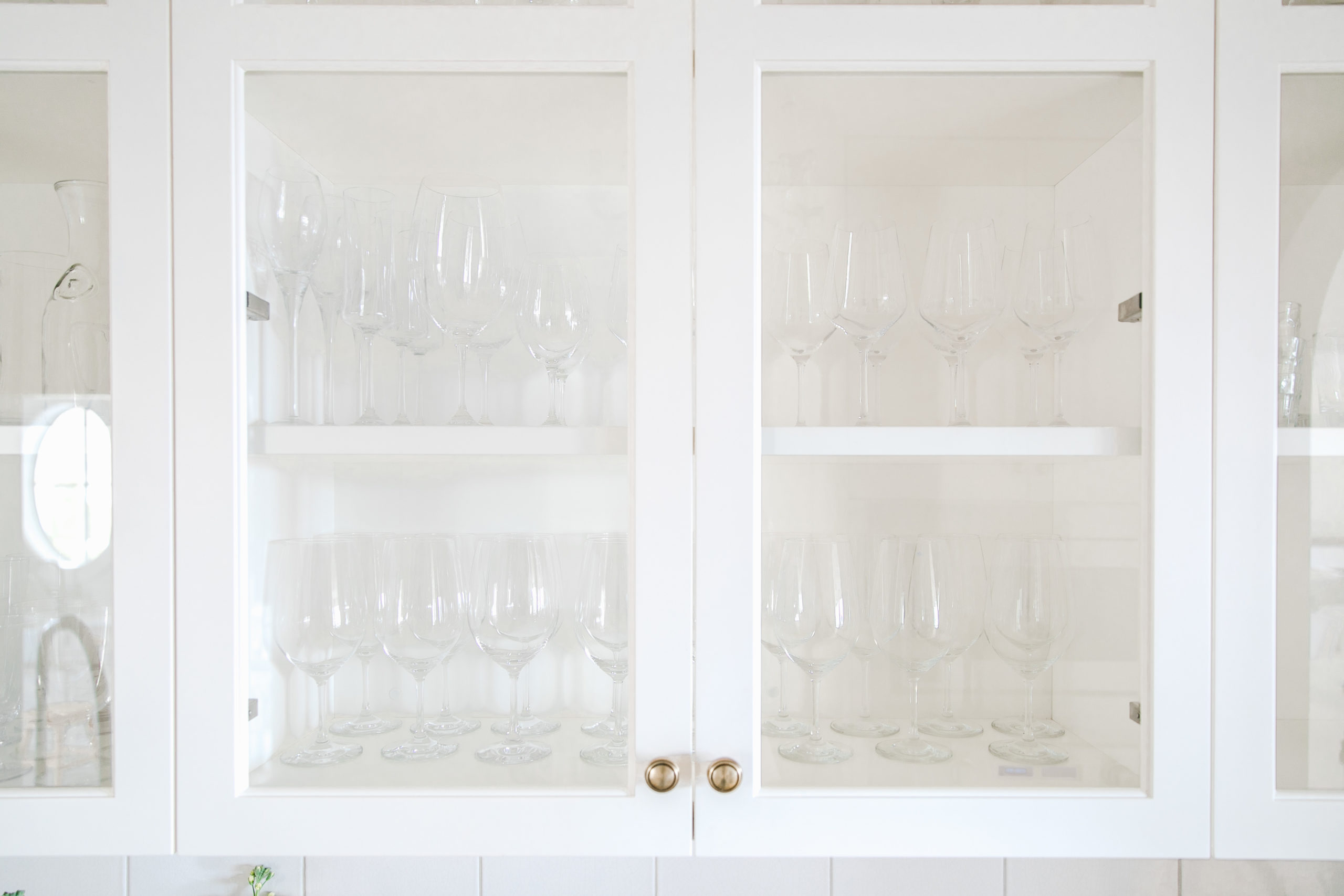 Our white butler's pantry reveal with an arched doorway, vintage chandelier lighting and open shelving. 