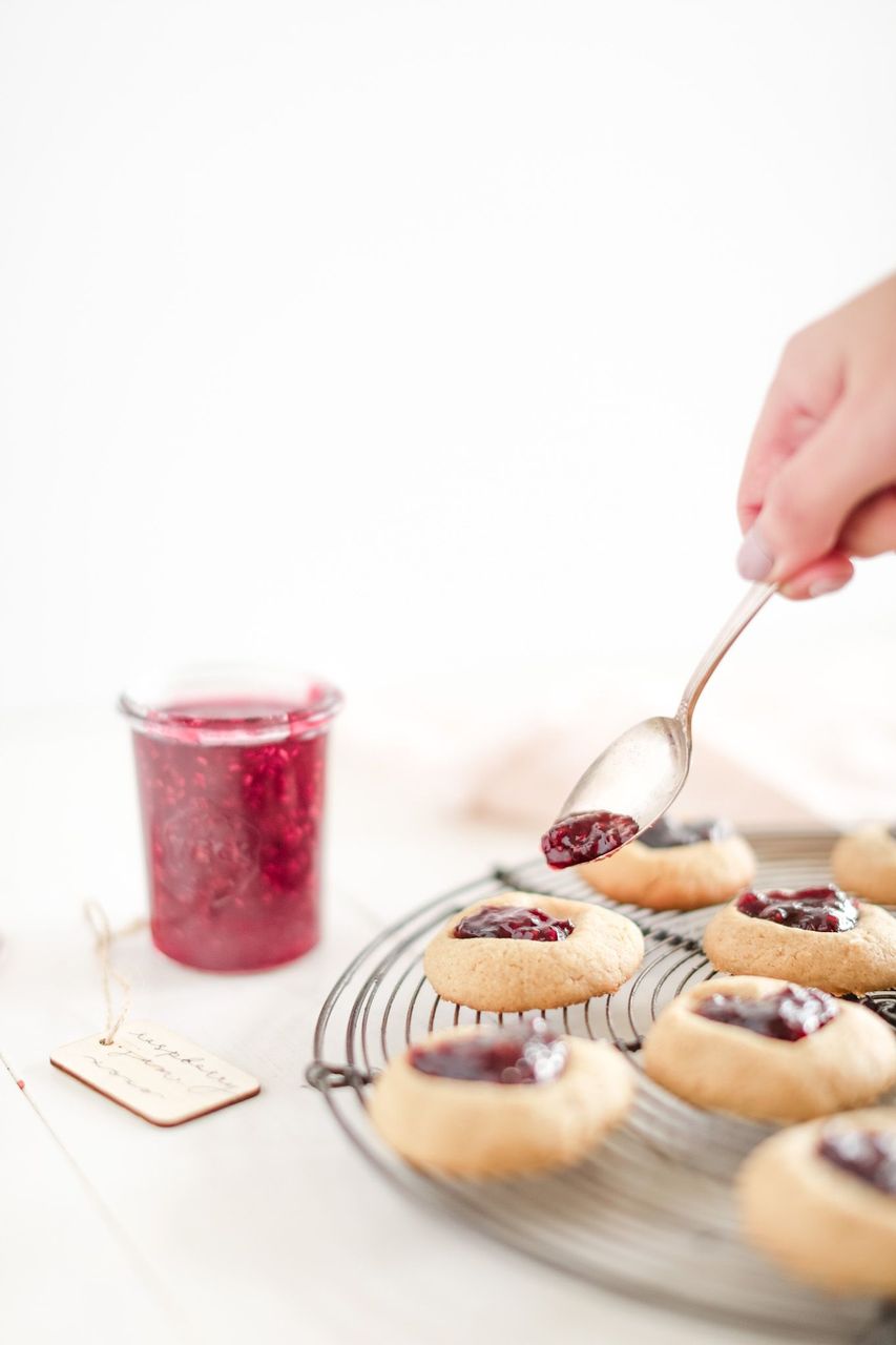 filling thumbprint cookies with jam