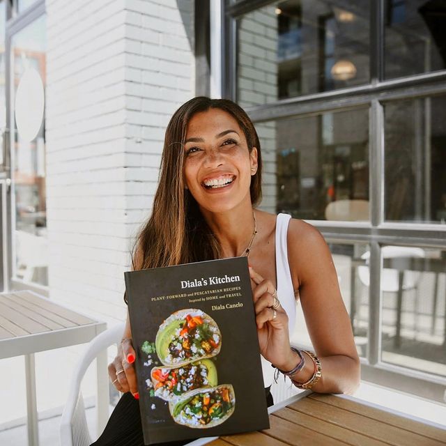 Diala holding her cookbook Diala's Kitchen 