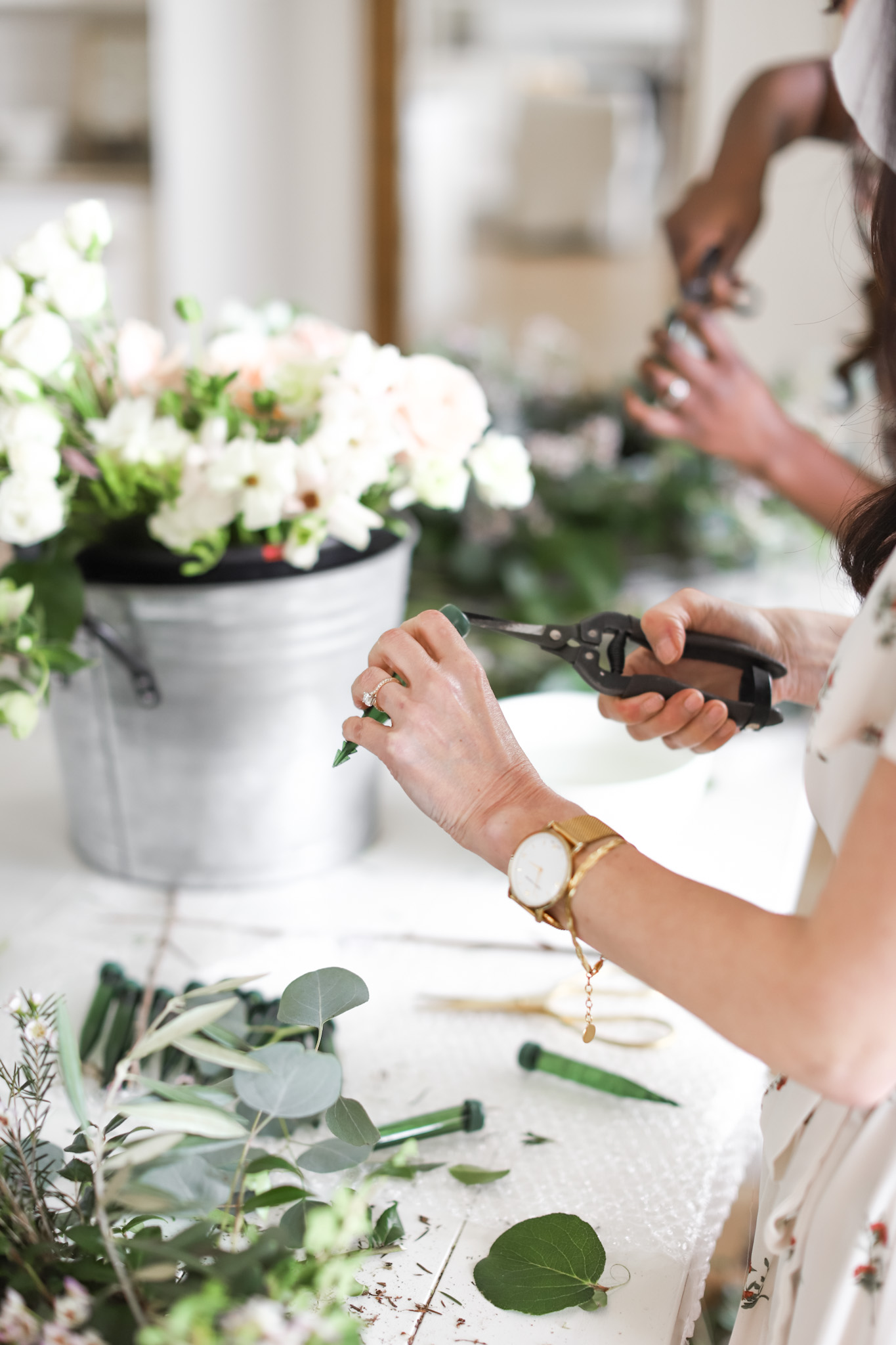 hands using a floral tube for a fresh flower wreath