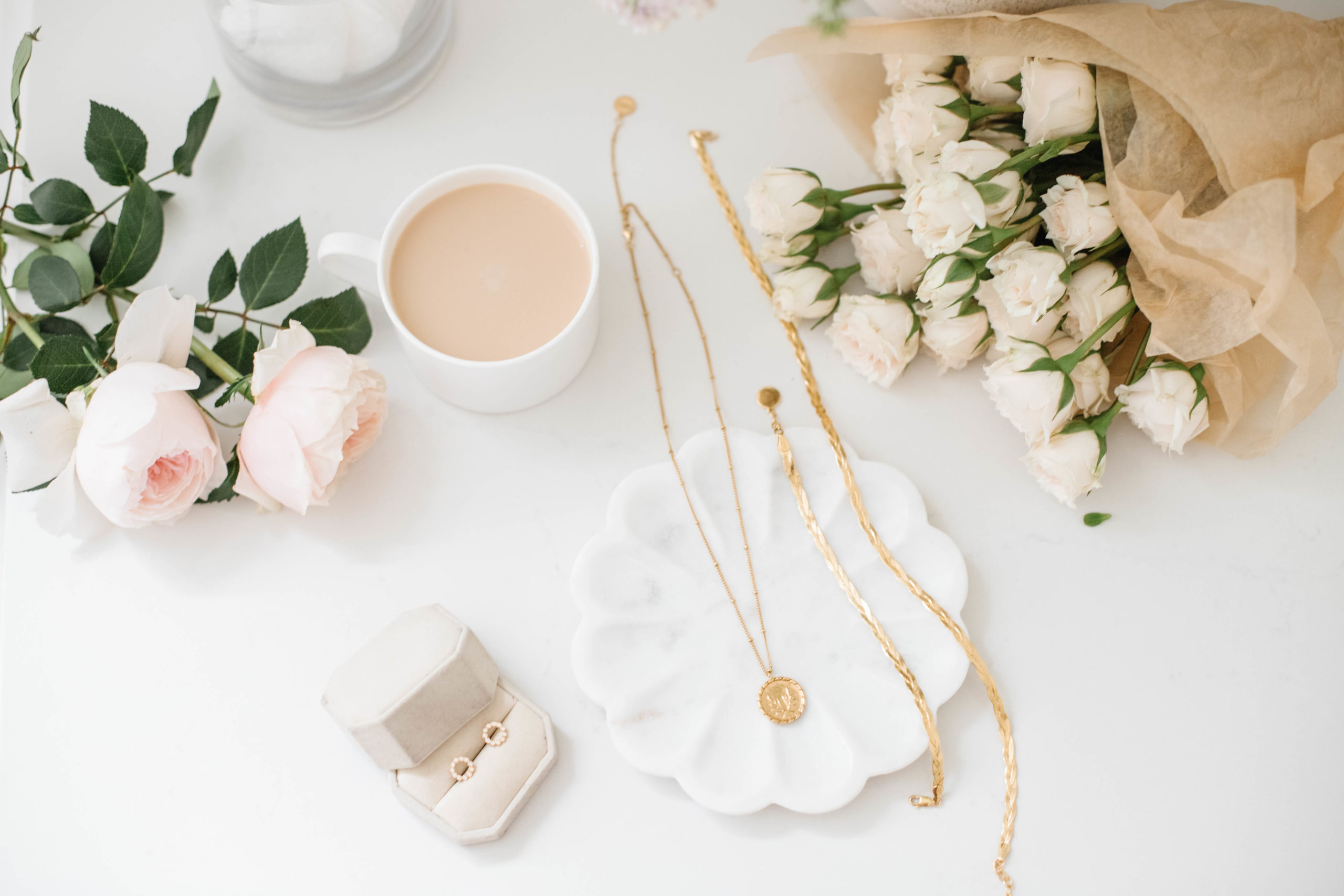 image of necklaces and earrings with a cup of coffee and roses