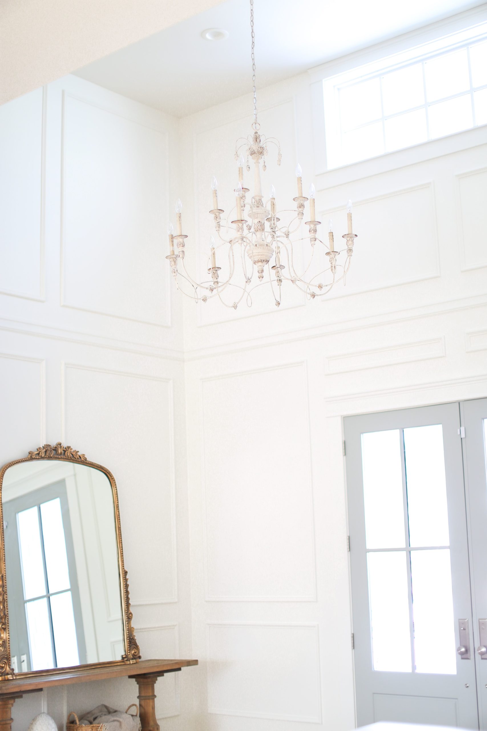 Tori Wesszer from Fraiche Living Entryway with oversized chandelier, Anthropologie Mirror and Moulding from Metrie