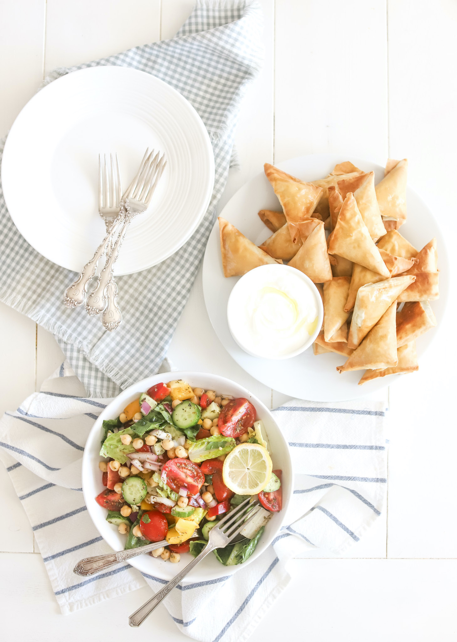 green greek salad with spanakopita and plates
