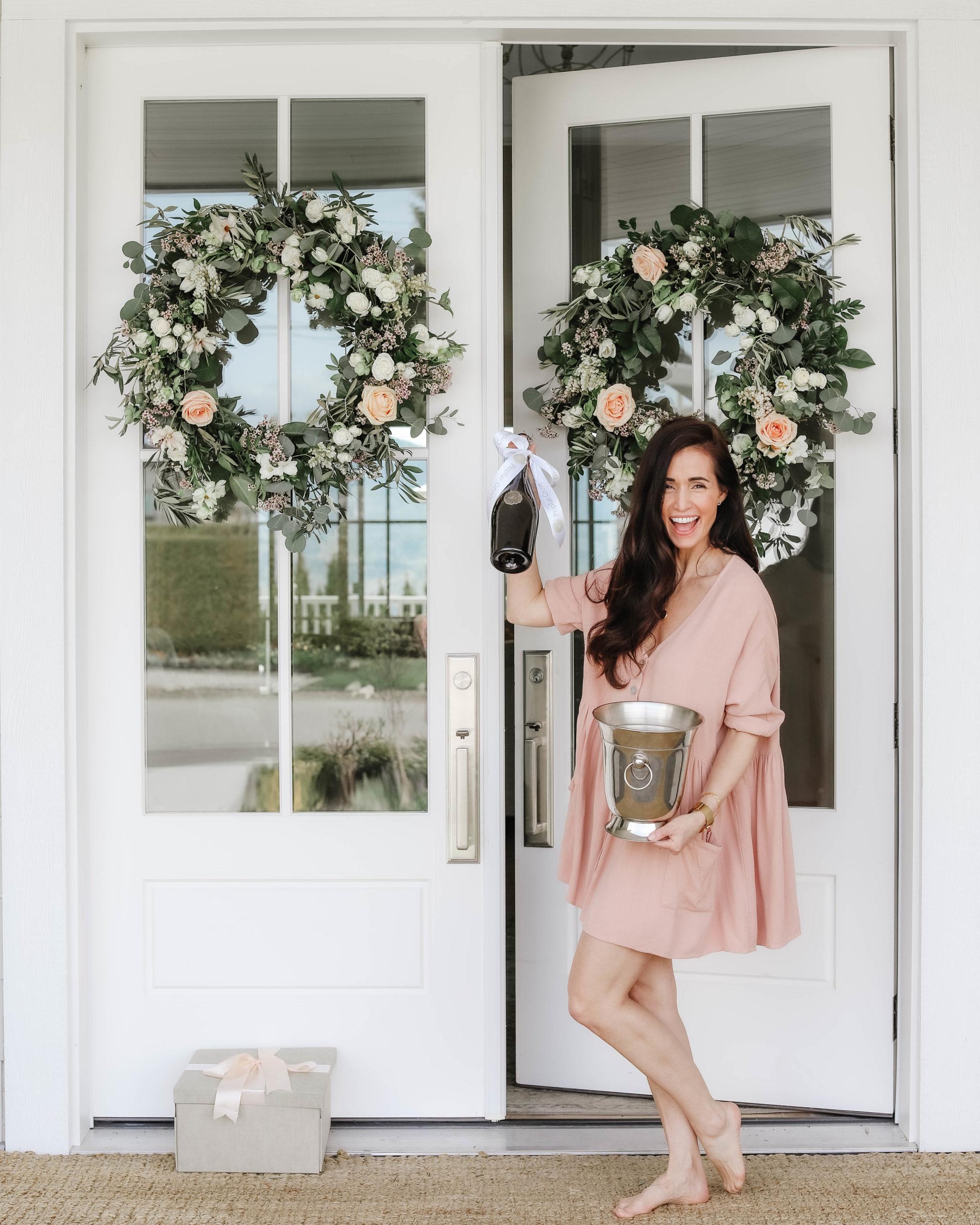 Tori Wesszer Fraiche Living smiling with a bottle of poplar grove wine at her front door