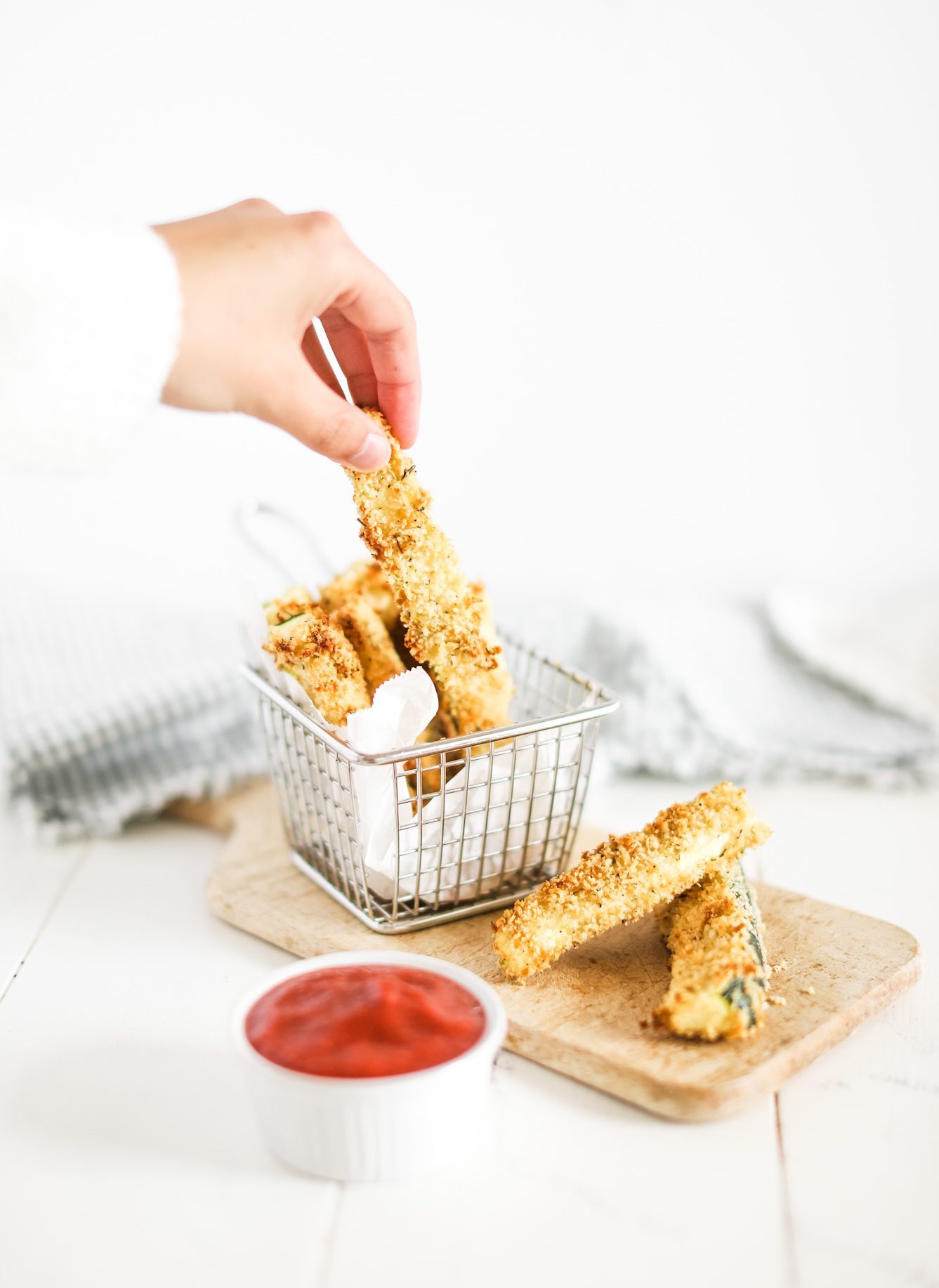 a hand grabbing Baked Zucchini Fries