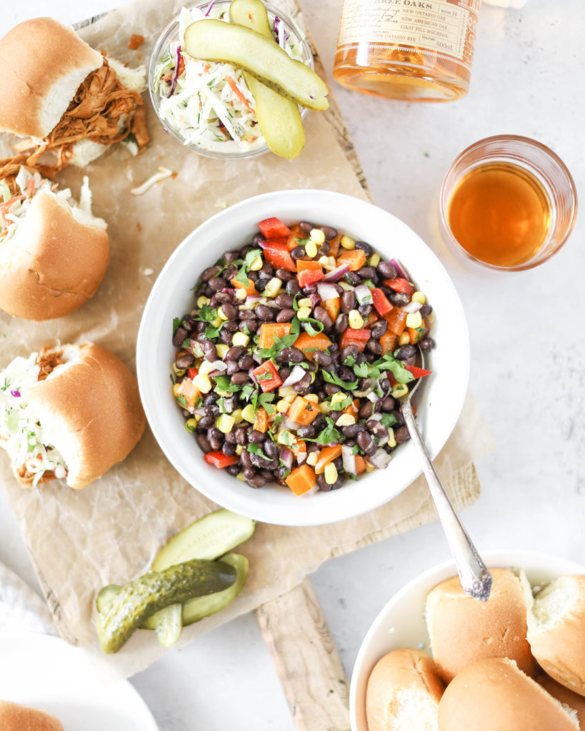 cowboy caviar salad in a bowl served on the side of chicken sliders