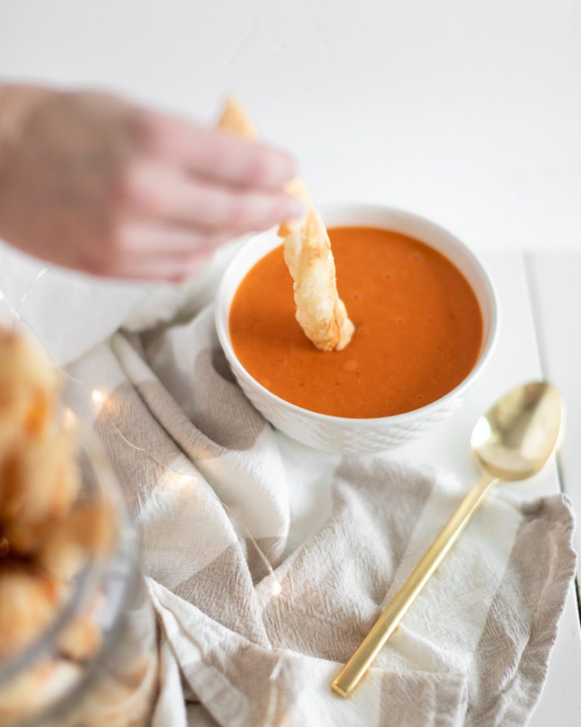 dipping cheese puff pastry twist into tomato sooup