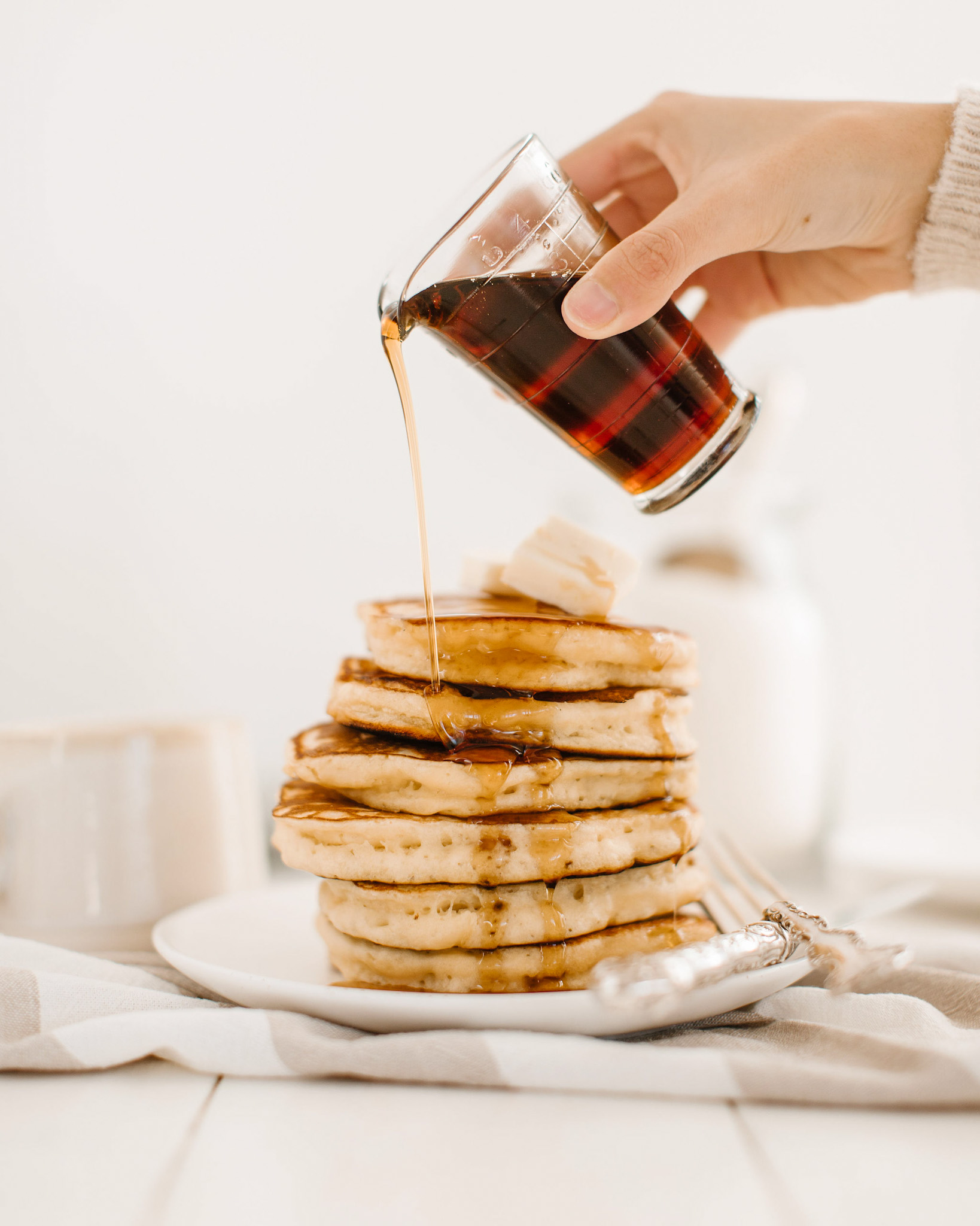 Pouring syrup over pancakes