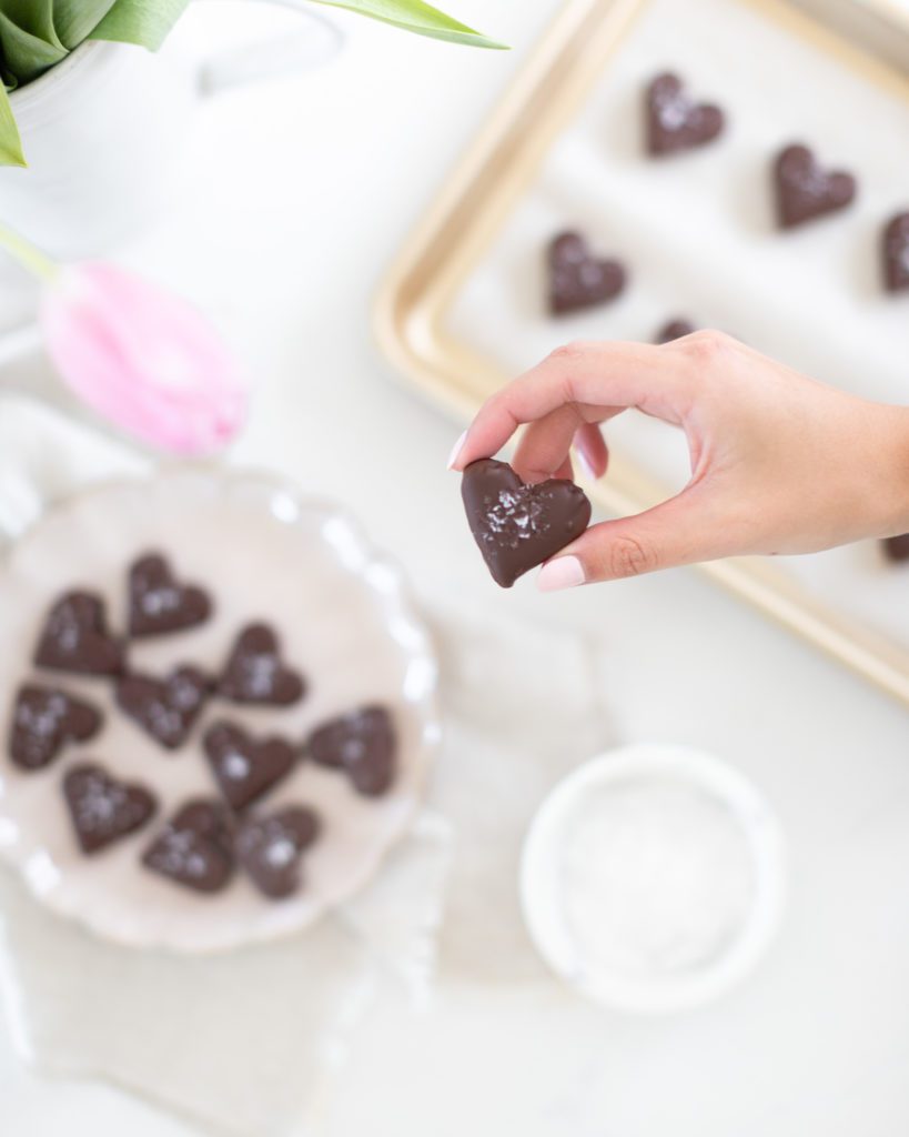 Hand holding a heart shaped Chocolate Covered Date Turtles
