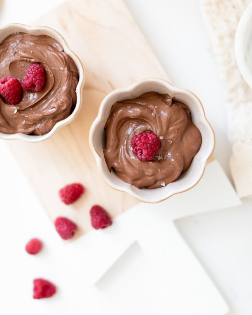 Two bowls of Vegan Chocolate Mousse topped with raspberries and sea salt