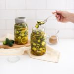hand grabbing pickles out of pickle jar