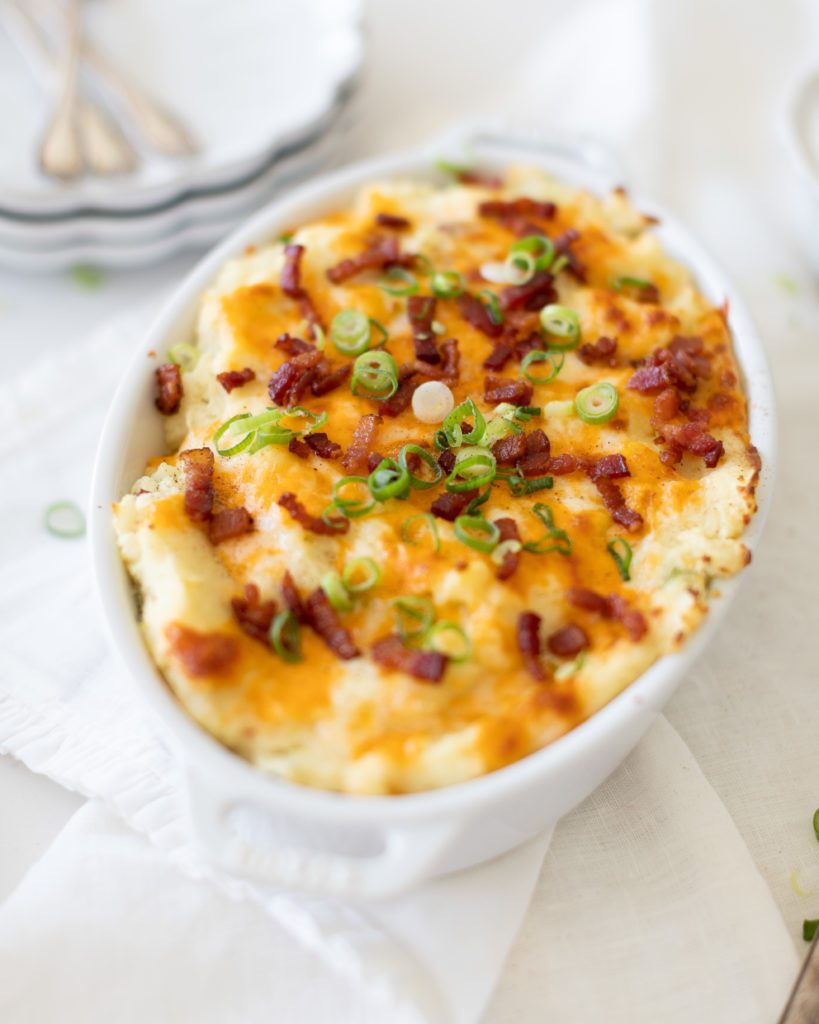 Loaded Mashed Potatoes win a baking dish with bacon, cheese and green onions on top