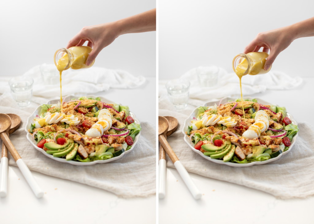 hand pouring salad dressing on to a bowl of Honey Mustard Chicken Salad