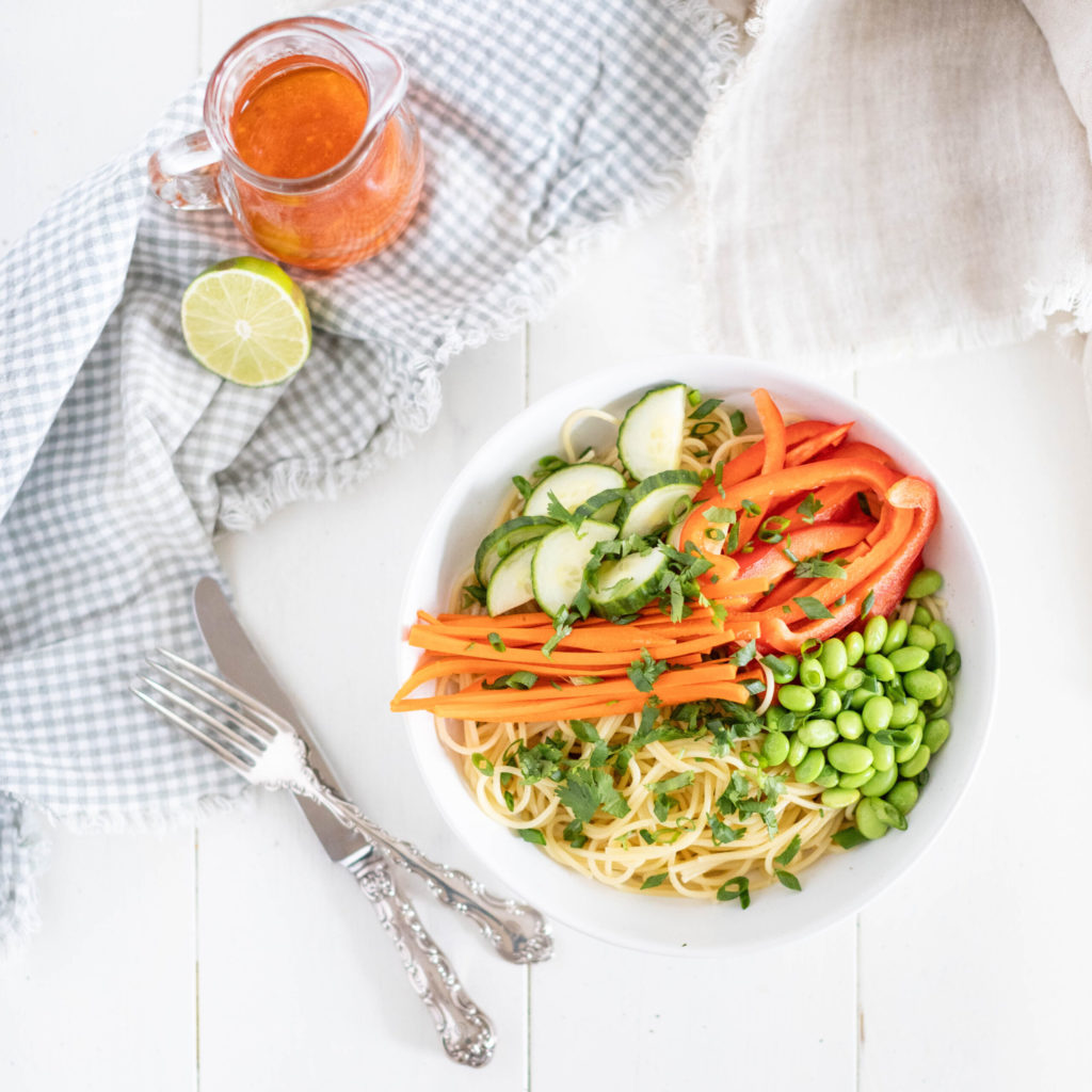 Fraiche Table Sweet Chili Noodle Salad in a bowl with shredded carrots, cucumber, bell peppers and edamame beans
