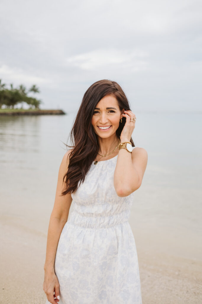 Tori on the beach in Hawaii in a short white and blue dress from The Fraîche x PRIV Summer Collection