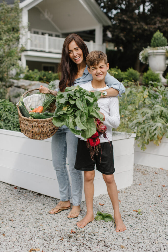 Mother and son smiling in vegetable garden
