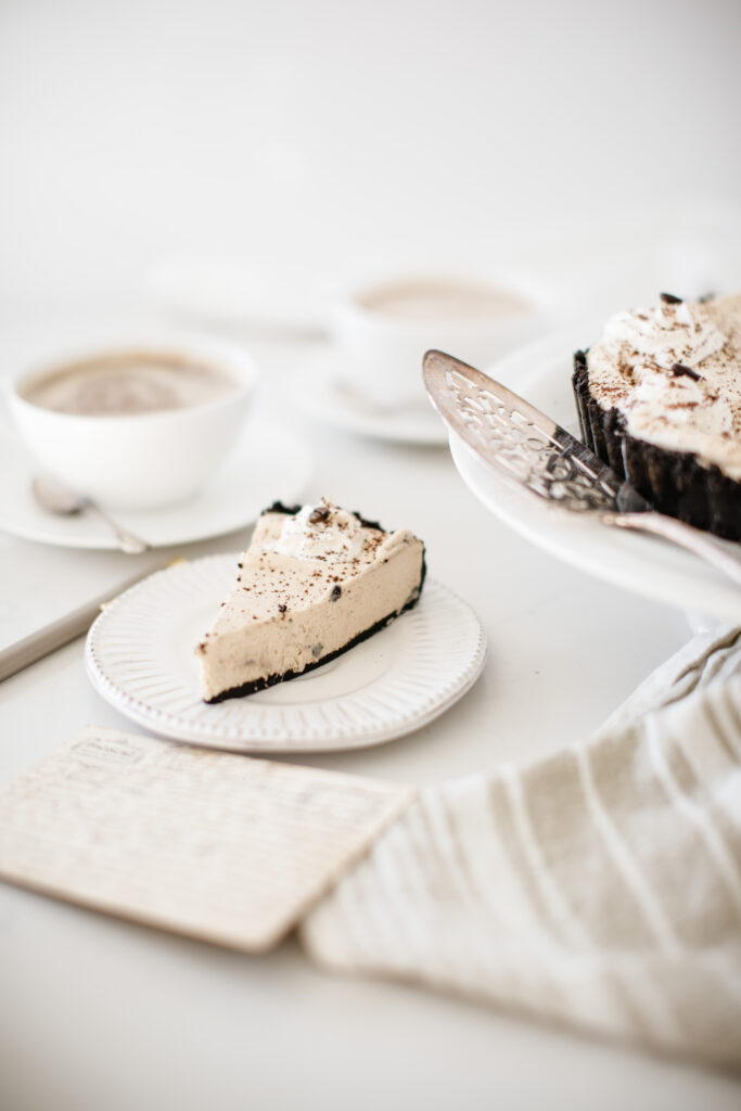 a slice of Café Au Lait Cheesecake on a small white plate
