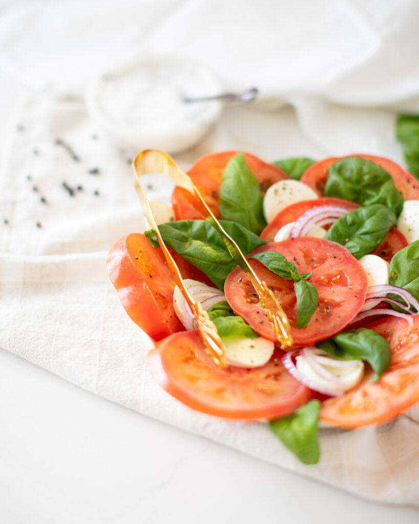 Caprese salad on a plate with tomato, basil, mozzarella and balsamic
